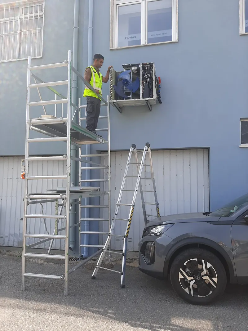 Instalação de unidade exterior de ar condicionado em altura em Loures, com andaime montado junto à fachada.