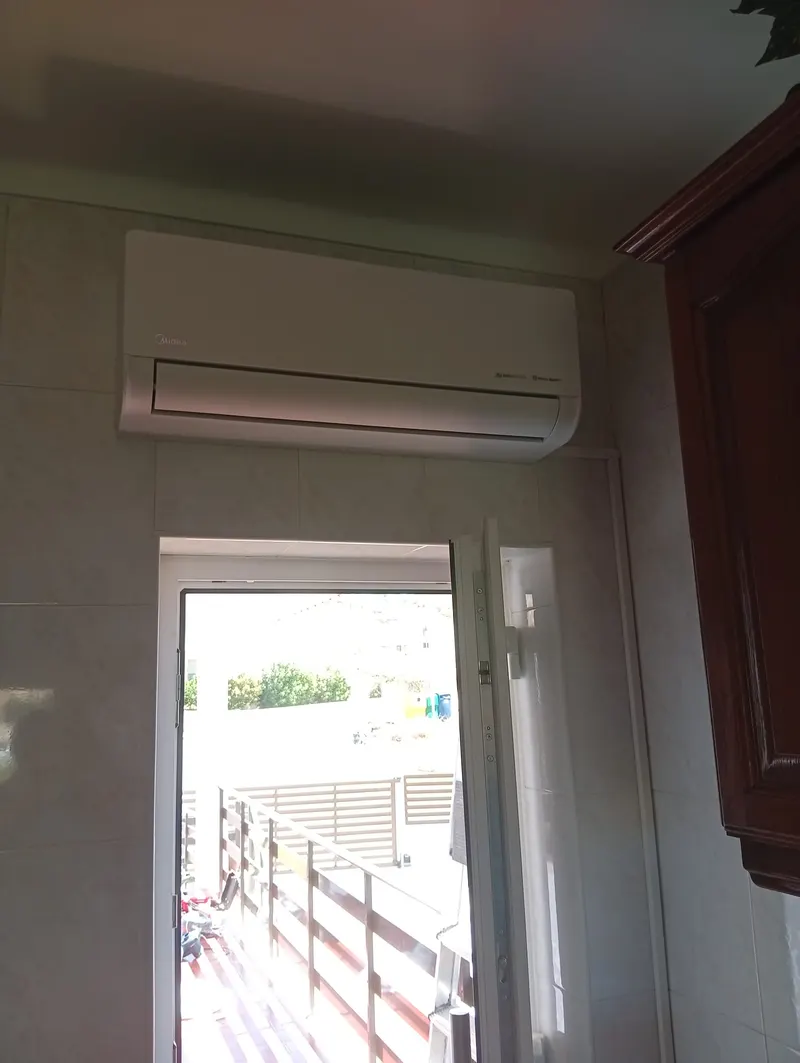 Unidade interior de ar condicionado por cima da porta de acesso à varanda, numa moradia em Alenquer.