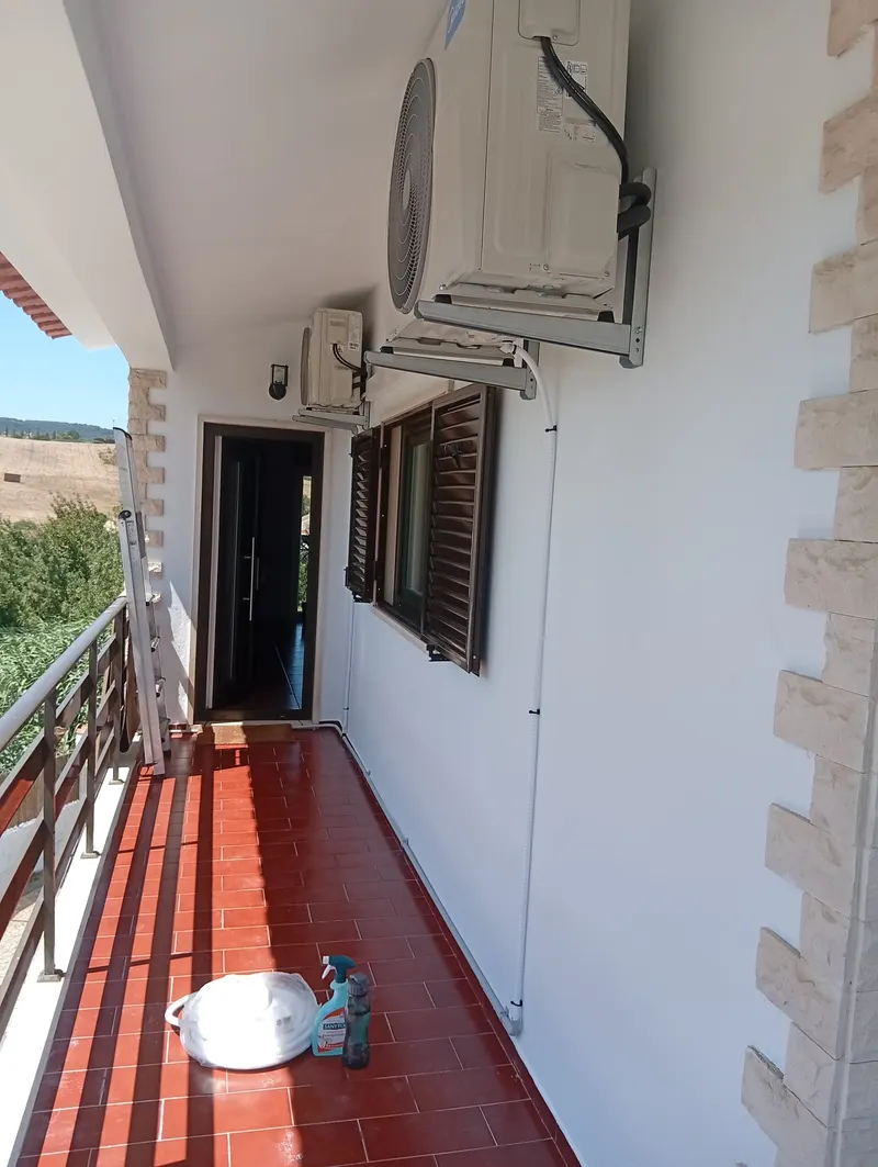 Unidades exteriores de ar condicionado instaladas na parede de uma varanda em Alenquer.