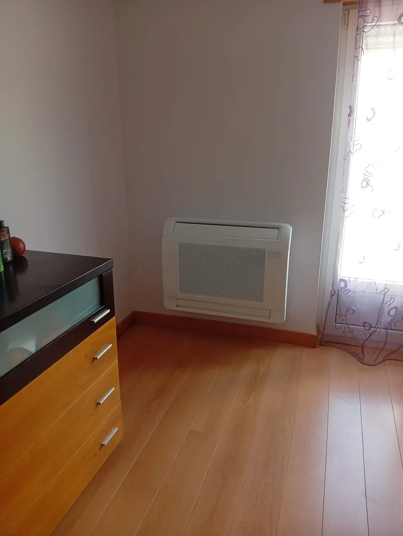 Ar condicionado de chão (consola) instalado num quarto junto à janela, em Sintra.