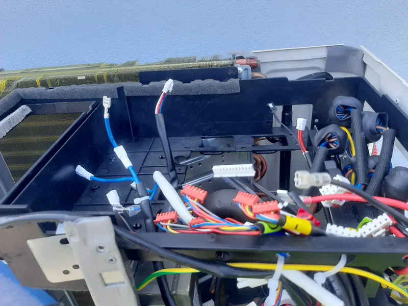 Ligações elétricas de uma unidade de ar condicionado, com a cablagem à vista.